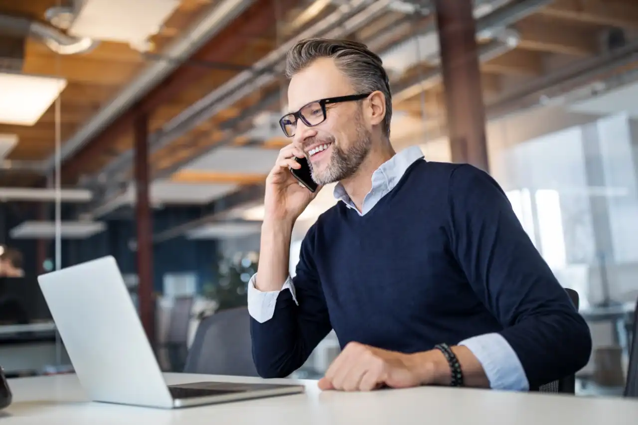 L'homme est au téléphone et regarde son ordinateur portable