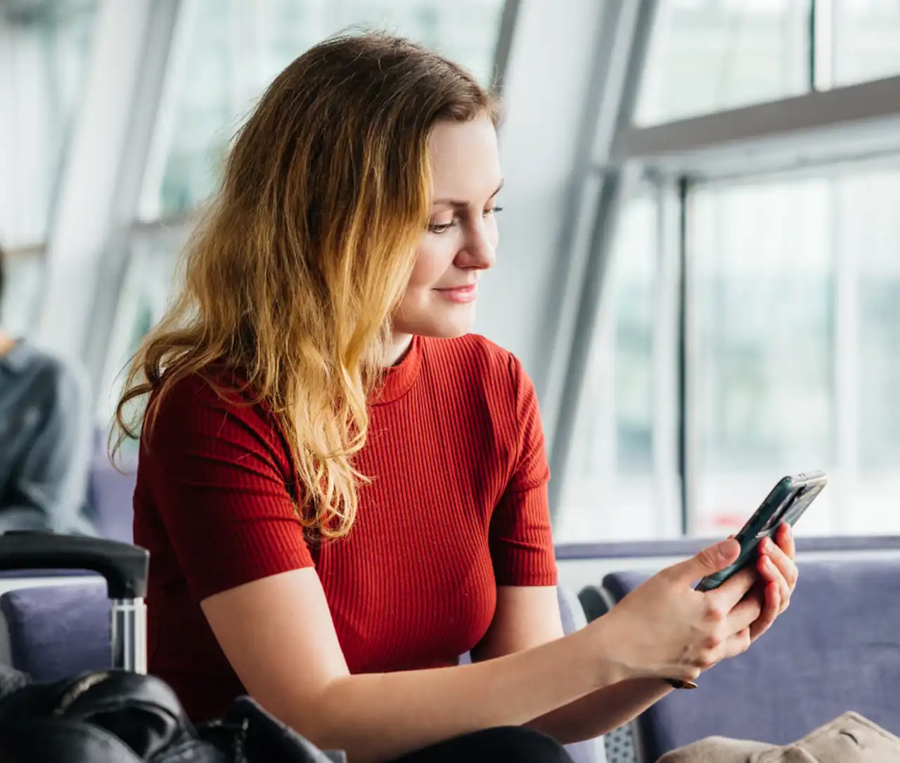 Donna con cellulare in aeroporto