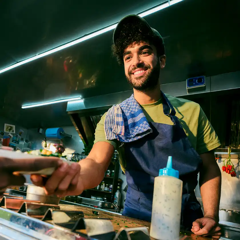 Cook from food truck serves food