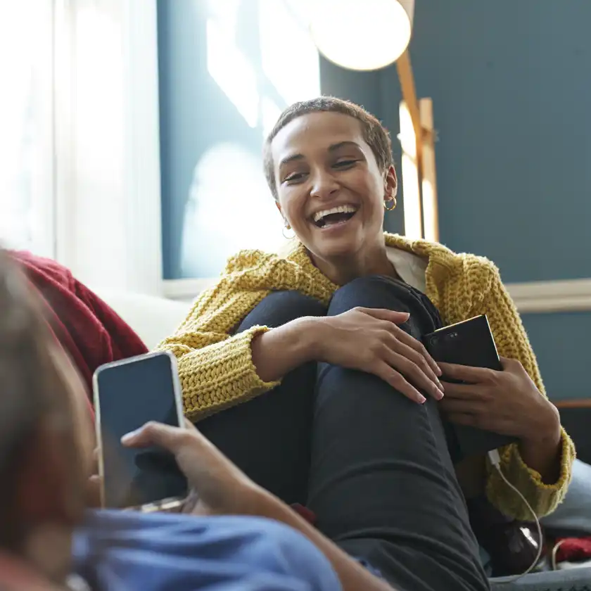 Couple with mobile phones on sofa