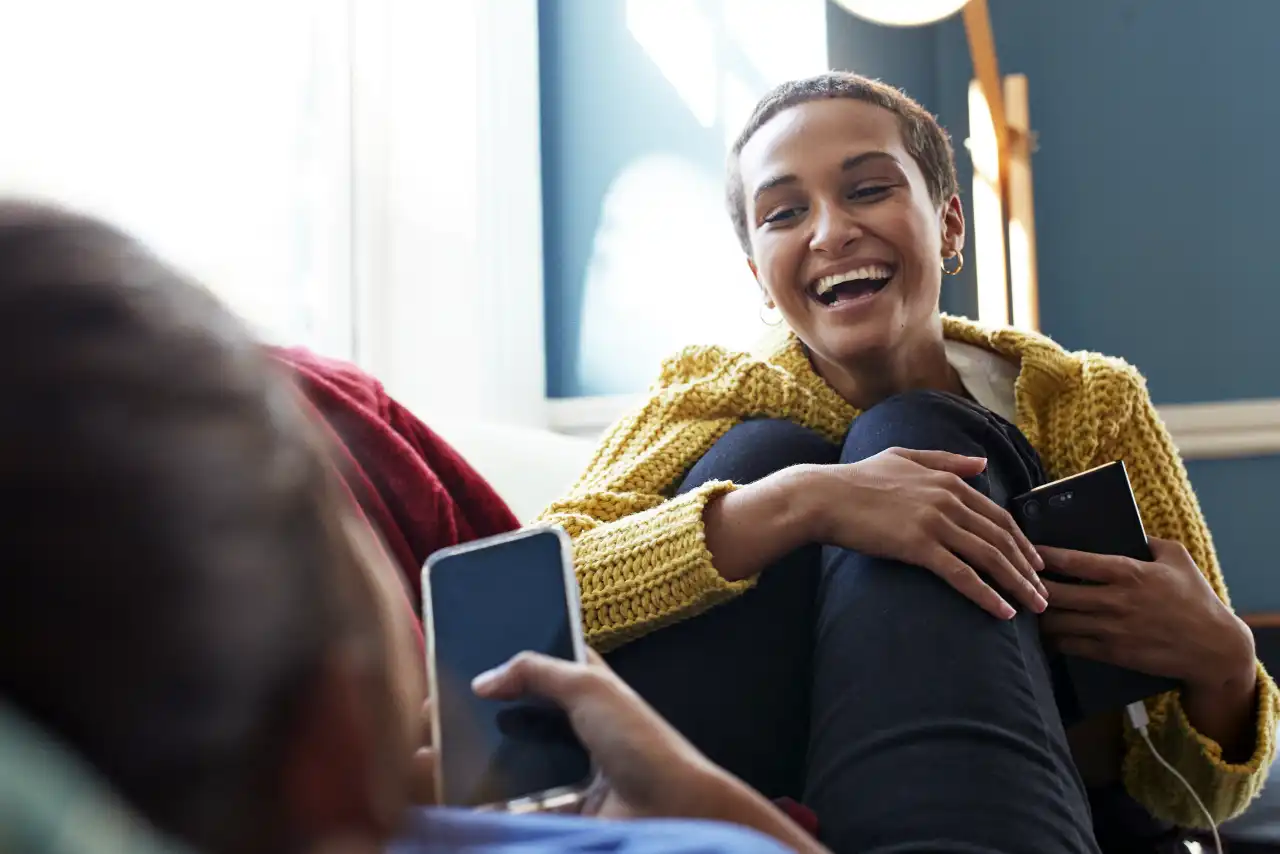 Couple with mobile phones on sofa