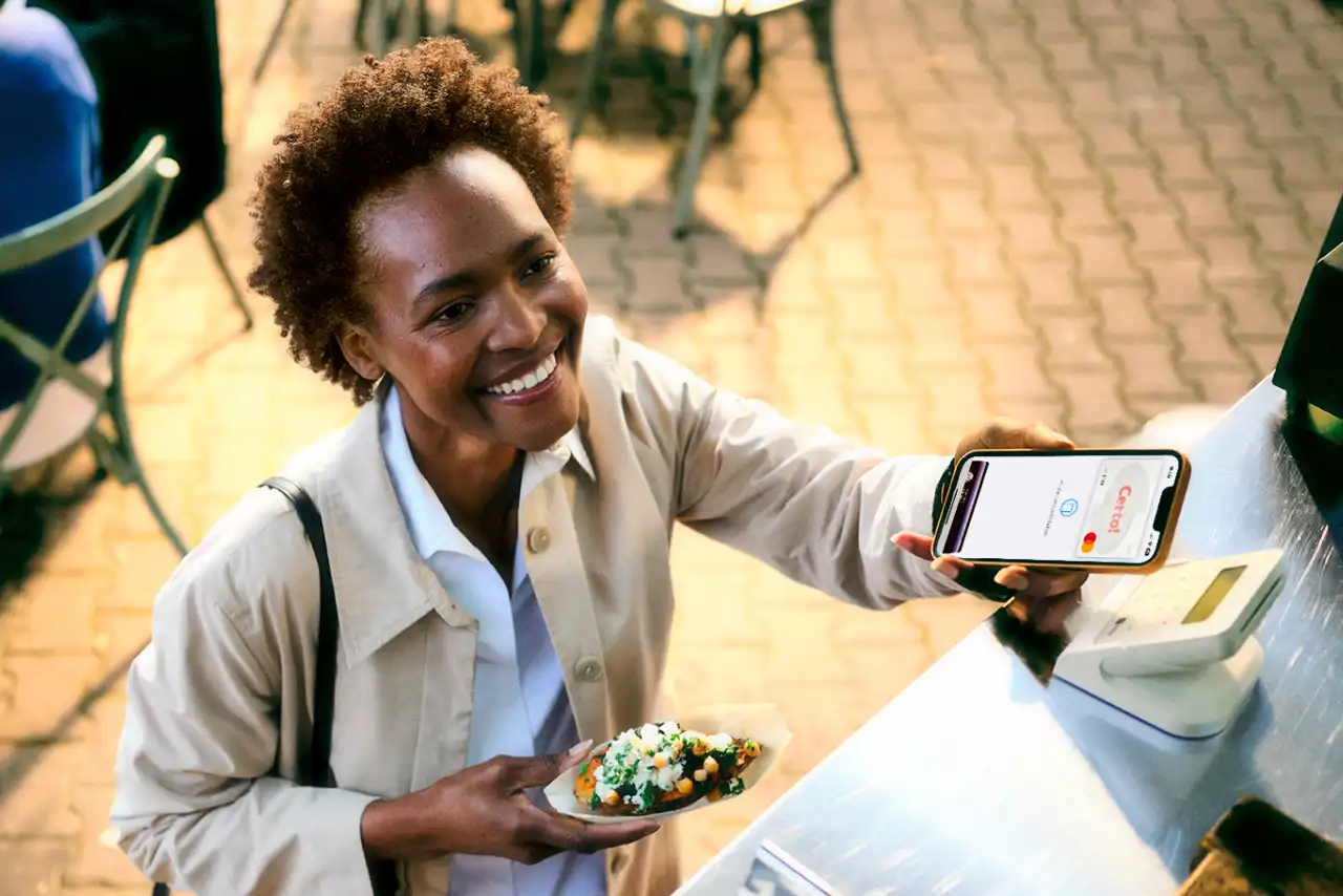 Frau bezahlt Essen mit Smartphone