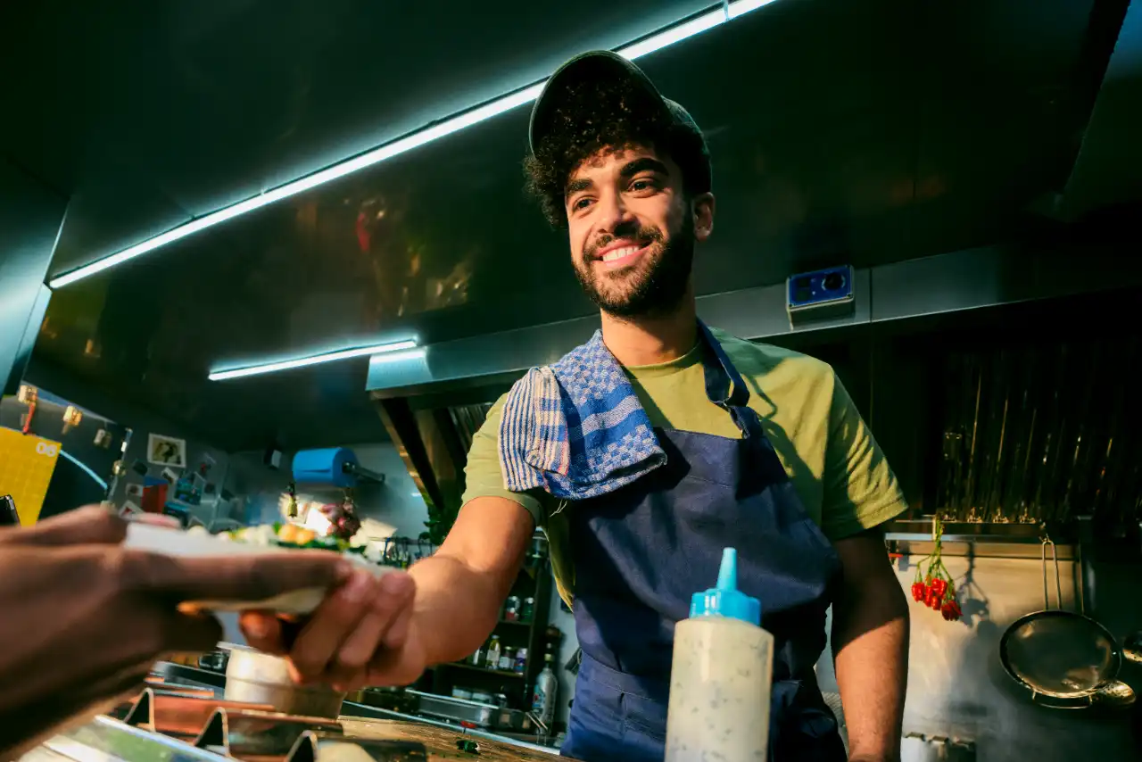 Cook from food truck serves food