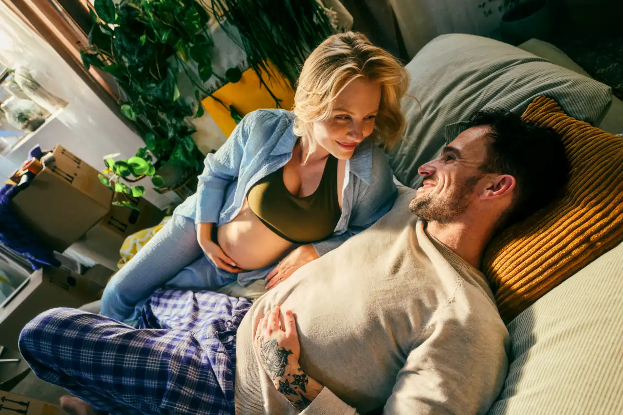 Un homme et une femme enceinte sur un canapé-lit