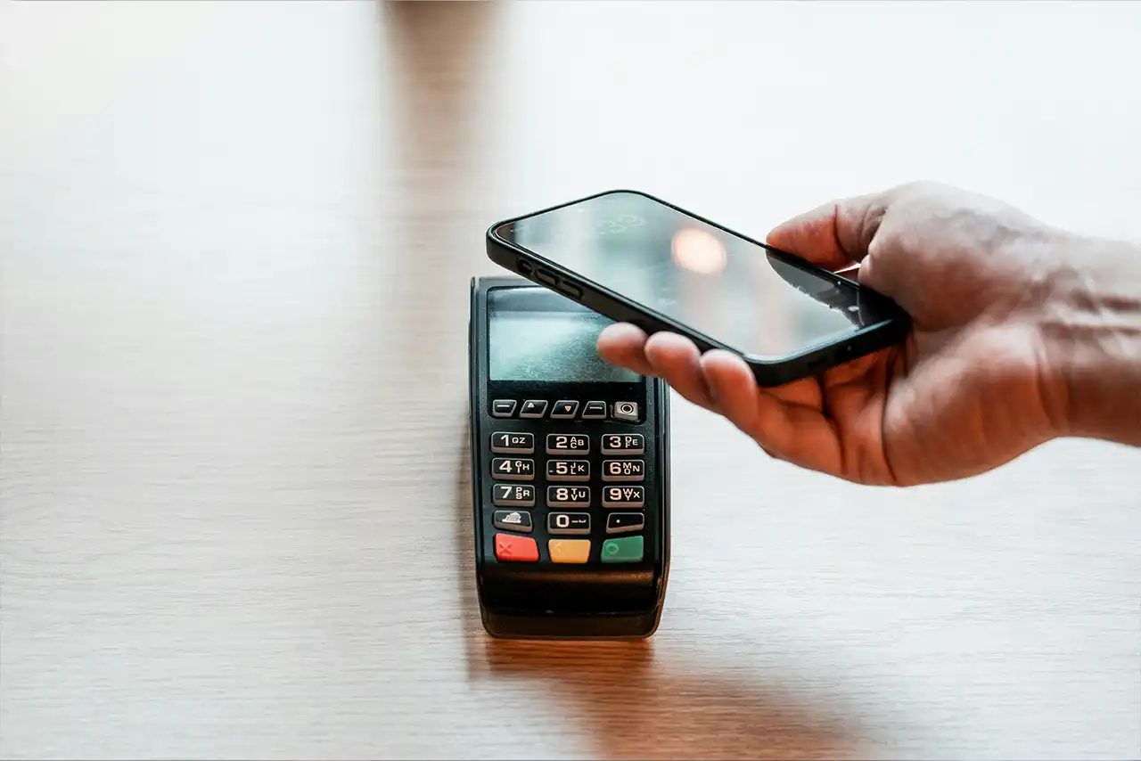 Une personne effectue un paiement sans contact avec son smartphone.