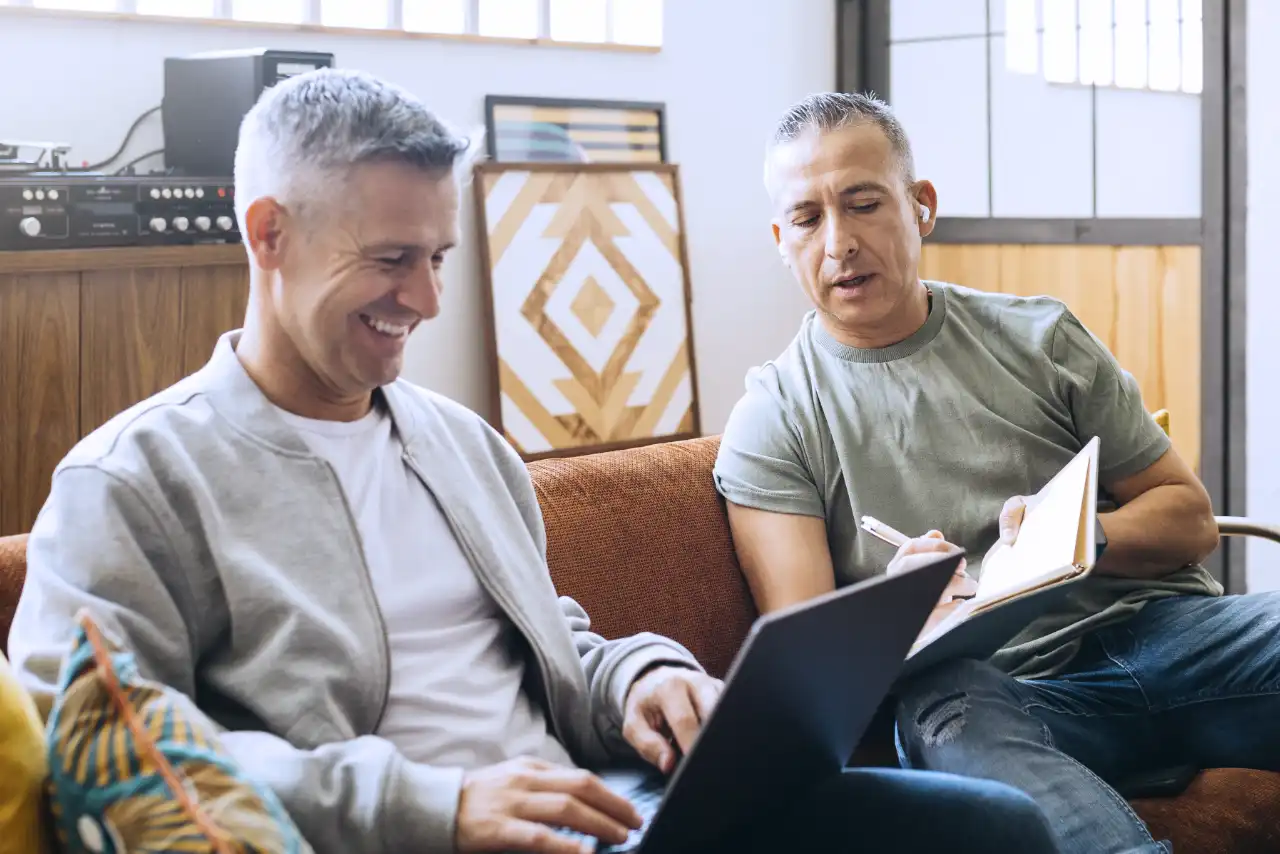 Two men working on a laptop