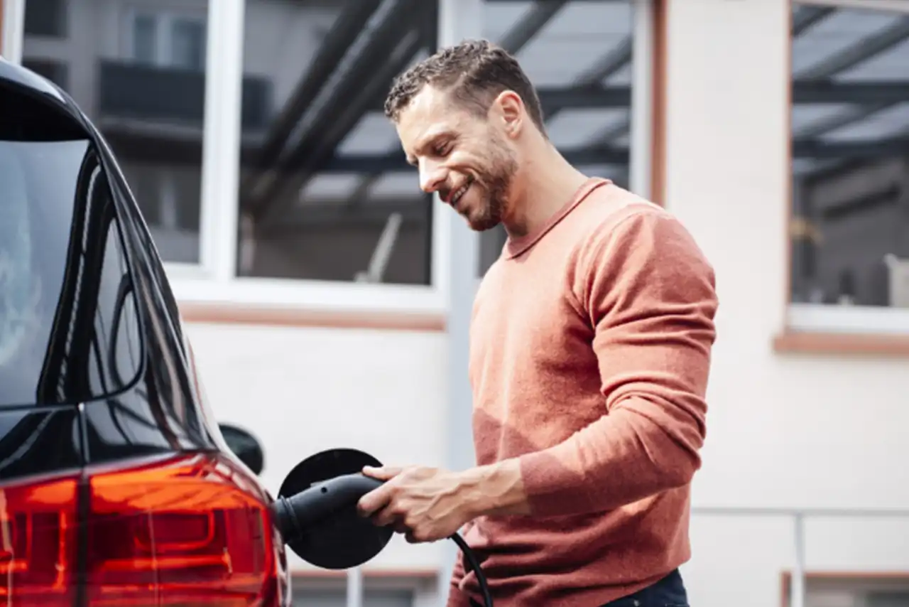 Un homme charge sa voiture électrique