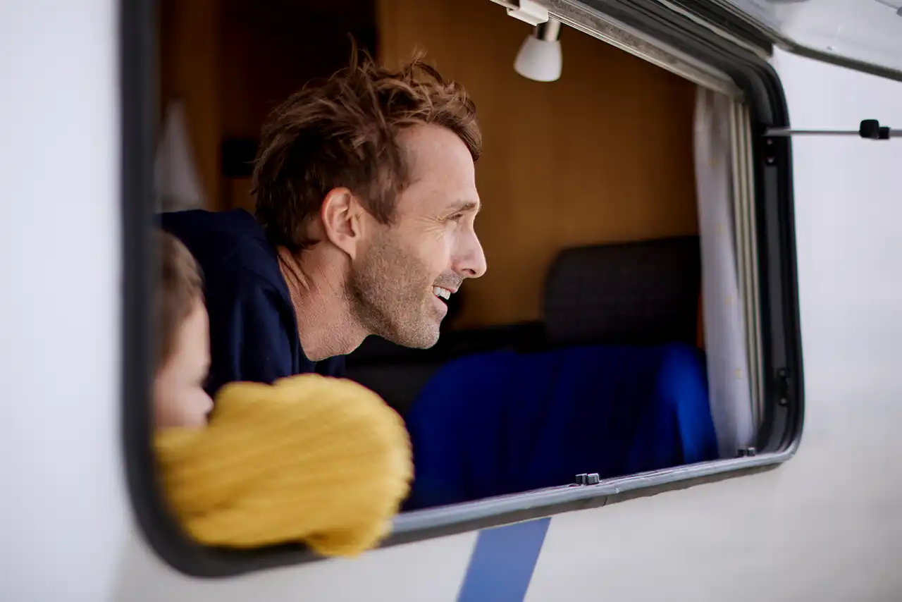 L'homme et l'enfant regardent par la fenêtre de la caravane