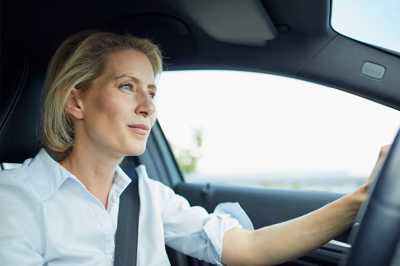 Une femme blonde au volant d'une voiture