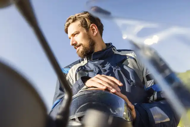 Uomo con abbigliamento e casco da moto