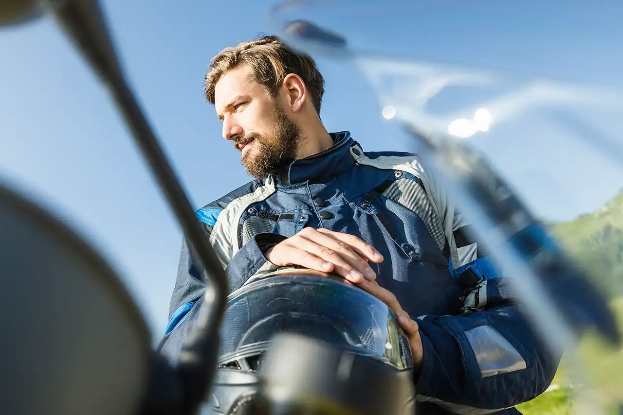 Mann in Motorradkleidung und Helm