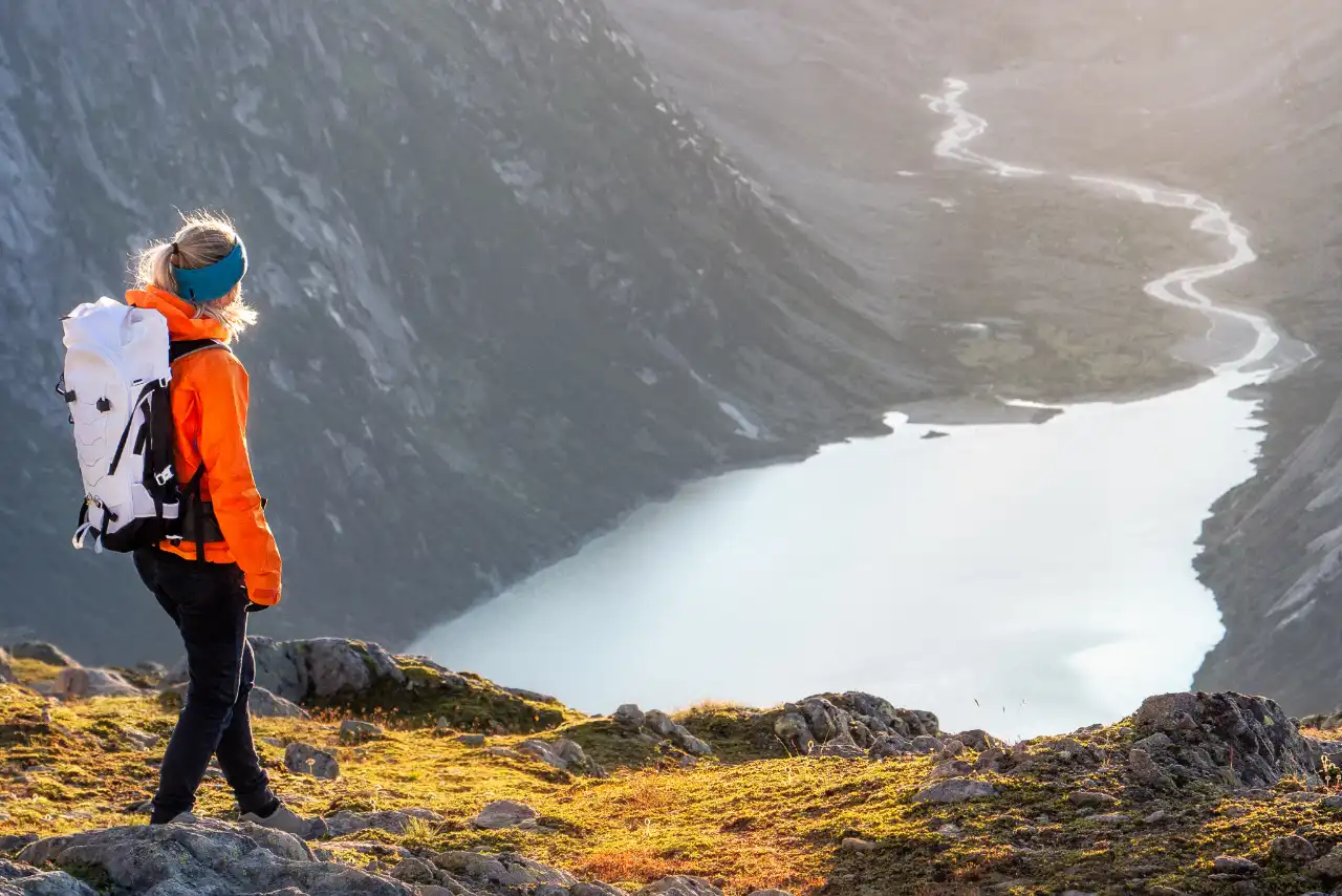 Frau am wandern mit Bergsee im Hintergrund