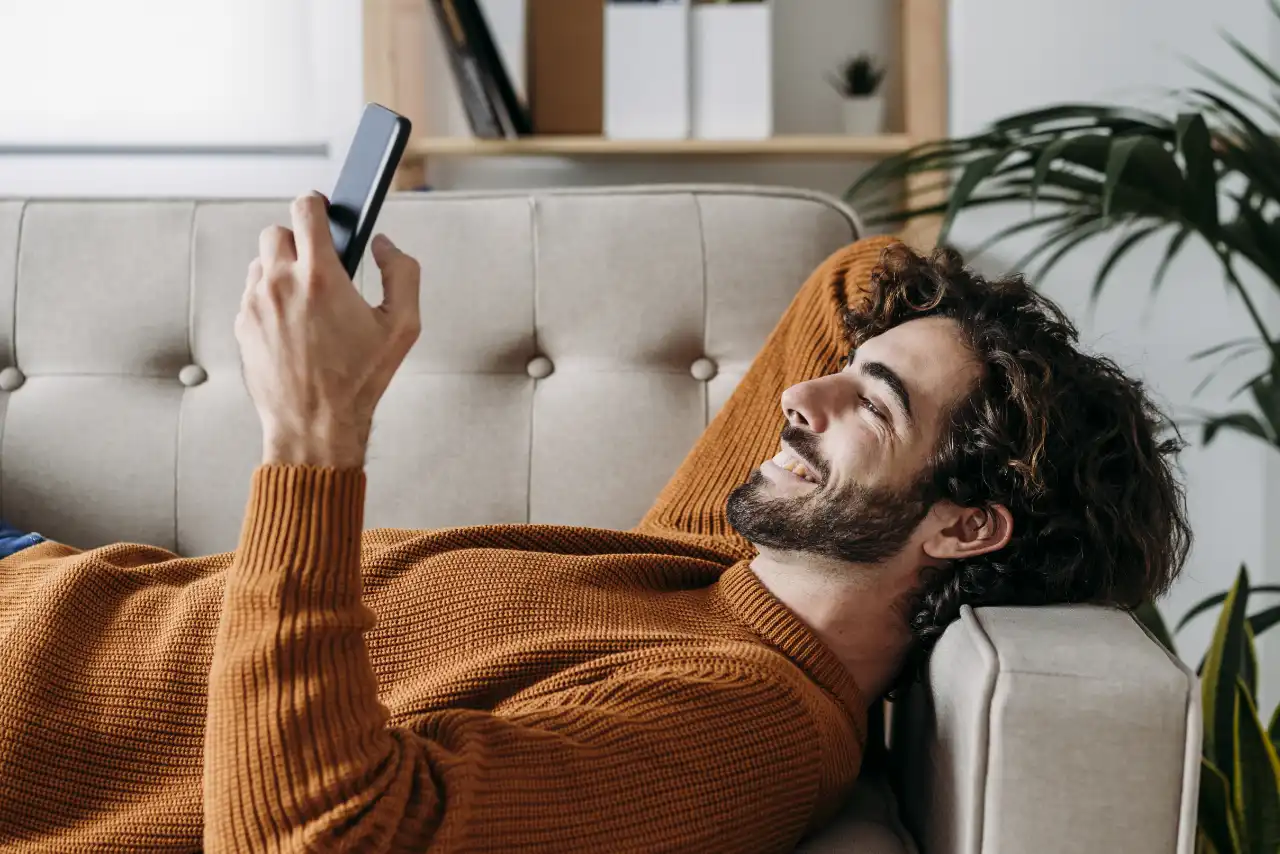 Homme avec téléphone portable sur le canapé