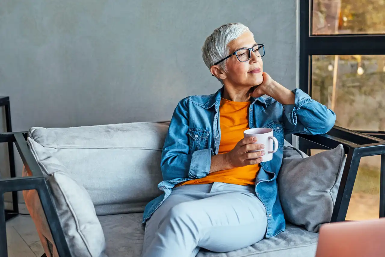 Woman with cup on sofa