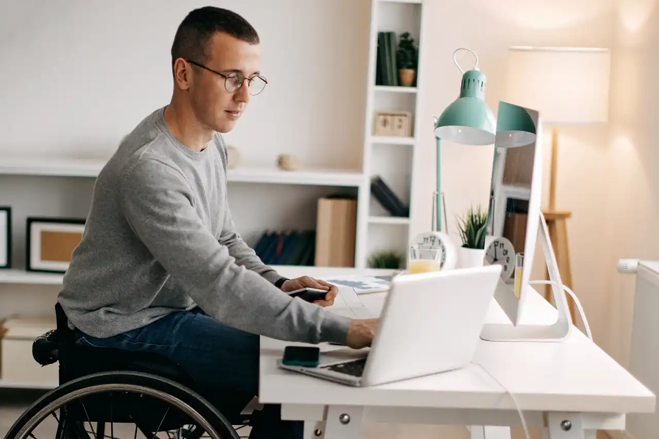 Homme en fauteuil roulant au pupitre