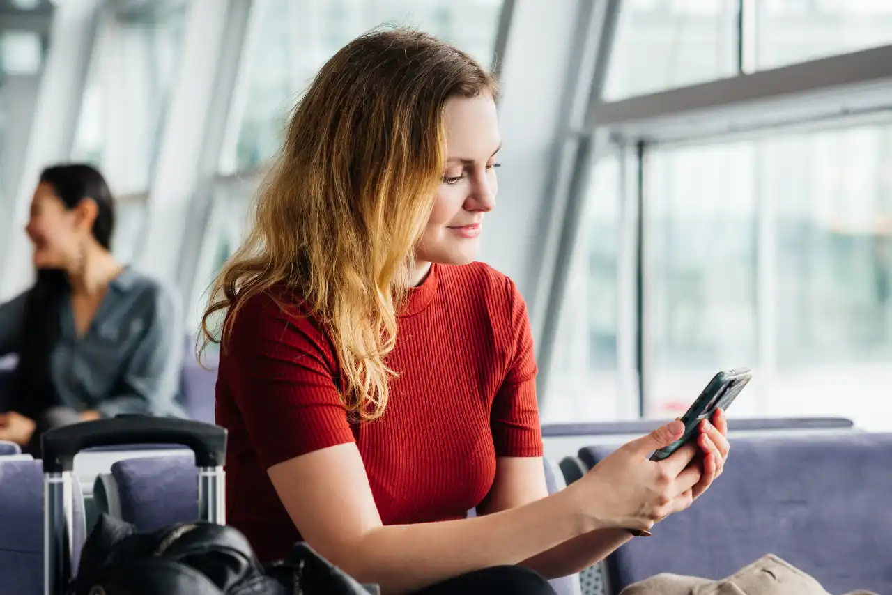 Une femme avec un téléphone portable à l'aéroport