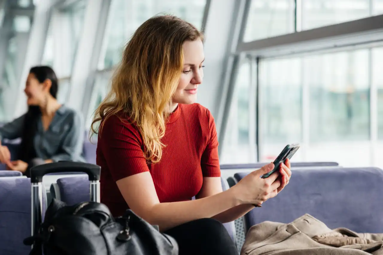 Frau mit Handy am Flughafen